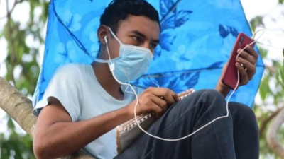 Joven salvadoreño sube a la copa de un árbol para no perder sus clases virtuales