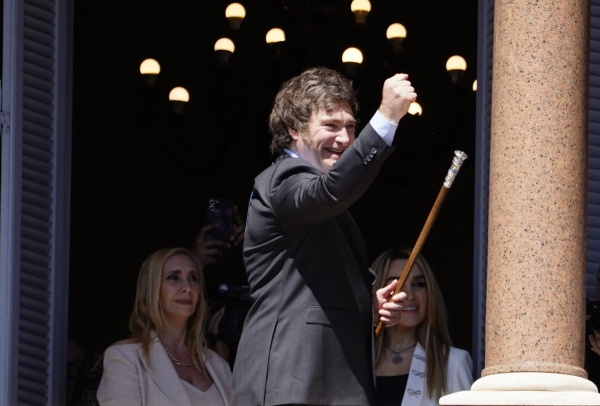 El presidente Javier Milei hace un gesto a la multitud que está en Plaza de Mayo, ante la mirada de Karina Milei y Fátima Flórez. Foto Emmanuel Fernández.