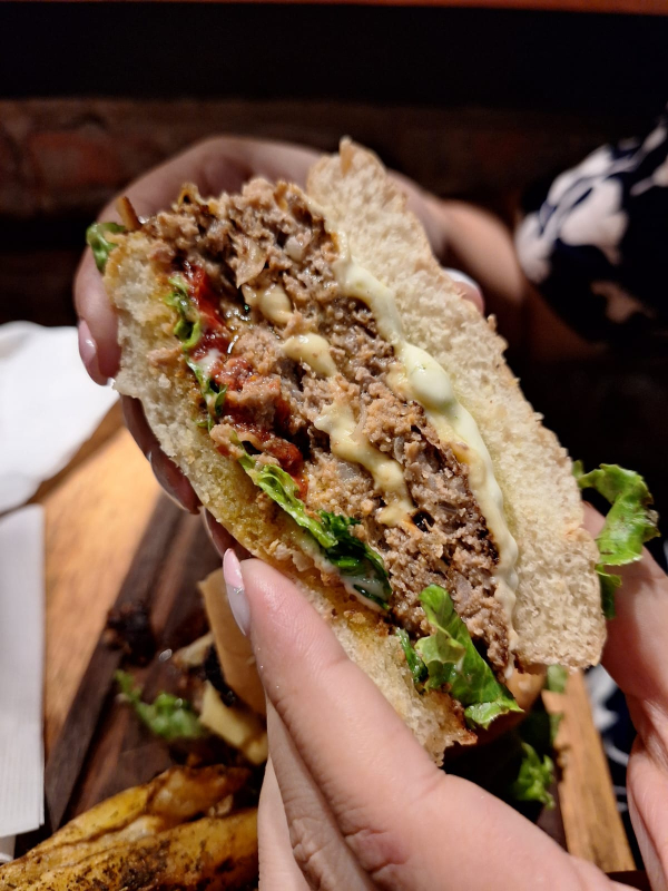 Italian Burguer de Mito, con doble medallón de carne, lechuga, tomates confitados caseros, salsa crema de albahaca y queso mozzarella, que incluye una porción de papas rústicas.