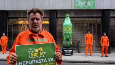 Milo Lockett pintó una botella de dos metros frente a oficinas de Coca Cola en protesta contra el desmonte de tierras