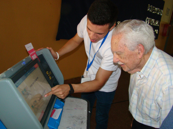 <p>  "GENERACIONES" Un joven indica a una persona mayor la forma de emitir su voto electrónico.  Foto: Fabián Maldonado </p>