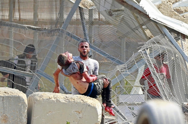 Un hombre se lleva a un palestino muerto en un ataque aéreo israelí en el cruce de Erez entre Israel y el norte de la Franja de Gaza. Foto: BASHAR TALEB / AFP.