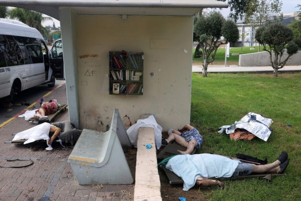 Los cuerpos de civiles asesinados yacen cubiertos en la ciudad sureña de Sderot el 7 de octubre de 2023. Al menos 40 personas murieron en Israel durante los combates con militantes palestinos. Foto de Oren ZIV / AFP.