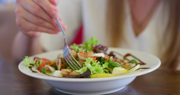 person-eating-fresh-vegetable-salad-with-grilled-chicken-on-a-white-plate-video.jpg