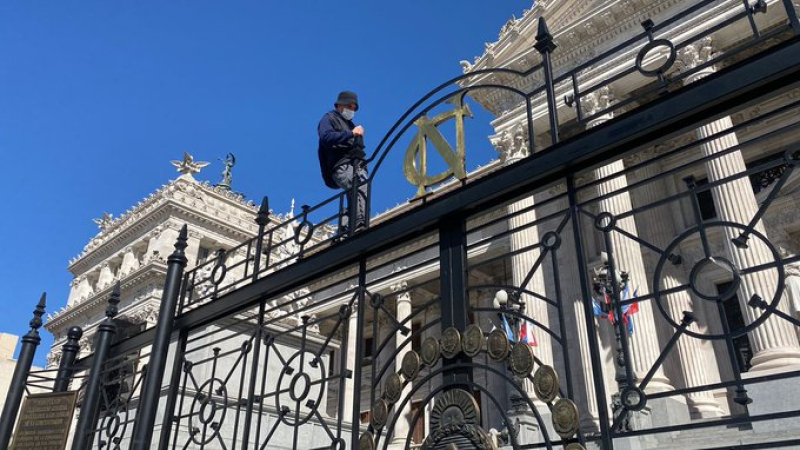 Trepó y se encadenó a la reja del Congreso porque "hay armas que controlan la mente"