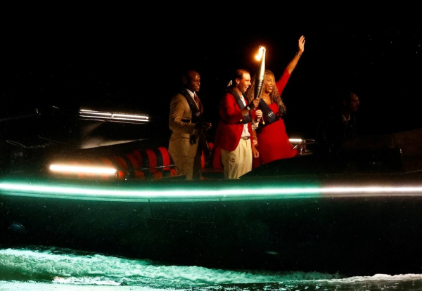 Rafael Nadal sostiene la antorcha olímpica junto a Serena Williams en un barco en el río Sena antes de encender el pebetero olímpico durante la ceremonia de apertura. Foto: REUTERS/Piroschka Van De Wouw.