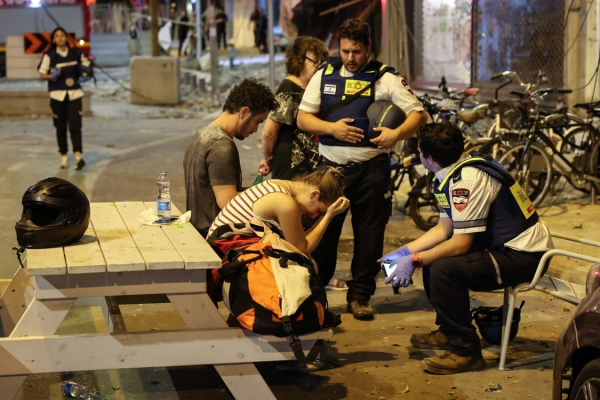 Una joven reacciona mientras habla con los rescatistas israelíes en Tel Aviv, después de que un cohete disparado por militantes palestinos desde la Franja de Gaza. Foto: JACK GUEZ / AFP.