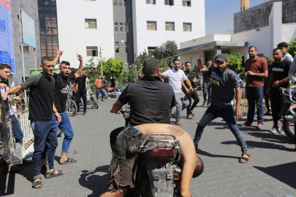 Un palestino viaja con el cuerpo de un israelí asesinado por militantes de Hamas en un kibutz cerca de la valla de la Franja de Gaza en la ciudad de Gaza. Foto AP/ Abed Abu Reash.