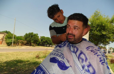 Todo a pulmón: cortan el cabello por $2000 en el parterre de una avenida