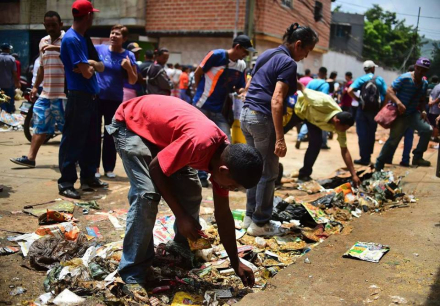 Vzla -El Valle Caracas recogen restos de alim tras saqueo supermercado.jpg
