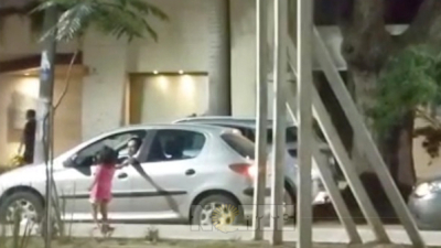Niños piden dinero mientras un adulto recoge lo recaudado